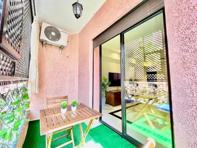 a patio with a wooden table and a glass door at Perfect stay in Guéliz Book now! in Marrakech