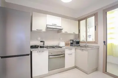 a kitchen with white cabinets and a stove top oven at La Bella Casa - Private Pool in Marrakech