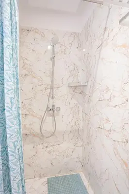 a shower in a bathroom with a marble wall at La Bella Casa - Private Pool in Marrakech