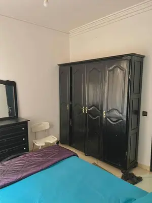 a bedroom with a bed and a black cabinet at Modern apartment in the heart of Marrakech, just 9 minutes from the airport in Marrakech