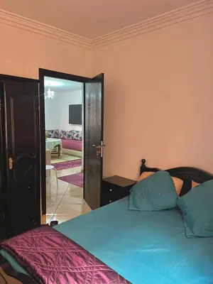 a bedroom with a bed and a door to a living room at Modern apartment in the heart of Marrakech, just 9 minutes from the airport in Marrakech