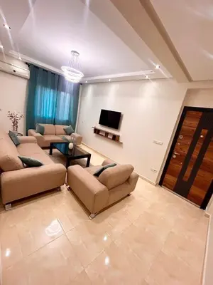 a living room with couches and a flat screen tv at Cozy Apartment 10 minutes from Gueliz and Medina in Marrakech