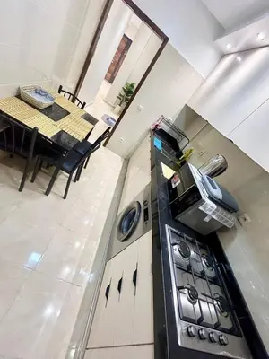 a kitchen with a stove and a dining table at Cozy Apartment 10 minutes from Gueliz and Medina in Marrakech