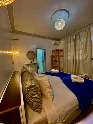 a bedroom with a large bed with a blue blanket at Dar Koutobia Stars in Marrakech