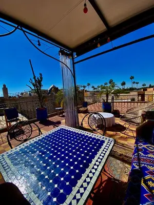 a screened porch with a table with a blue and white pattern at Dar Koutobia Stars in Marrakech