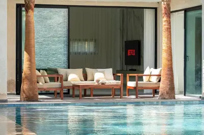 a resort with a swimming pool with chairs and a table at Villa Lana on stilts luxury and relaxation in Marrakech