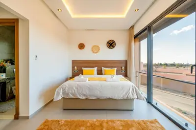 a bedroom with a large bed and a large window at Luxury 5-Suite Villa with private pool in GOLF Amlkis ,free Airport transport service in Marrakech