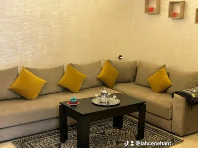 a living room with a couch with yellow pillows at Studio confort à Hivernage Piscine, parking & toutes commodités in Marrakech