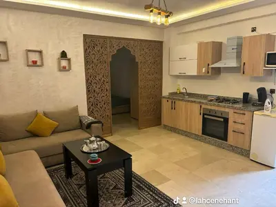 a kitchen and a living room with a couch and a table at Studio confort à Hivernage Piscine, parking & toutes commodités in Marrakech