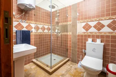 a bathroom with a shower and a toilet and a sink at Résidence Qodwa in Marrakech