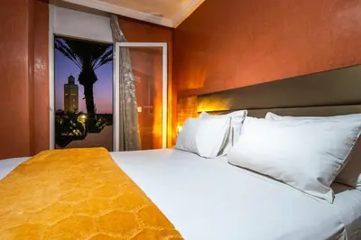 a bedroom with a large bed with white pillows at Résidence Qodwa in Marrakech