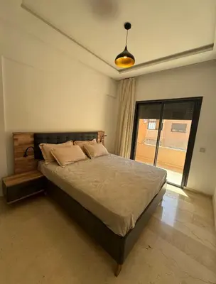 a bedroom with a bed and a large window at Marrakech résidence Nour 6 in Marrakech
