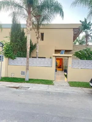 a yellow building with palm trees in front of it at Zen Villa Private Parking in El Rhechat