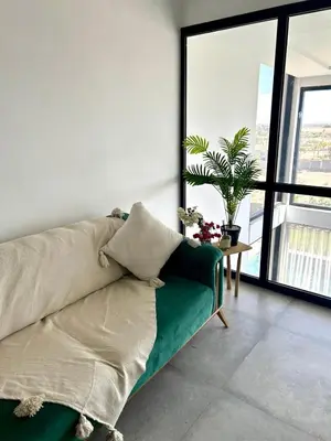 a living room with a green couch and a window at Villa LAM atlas view in Tameslouht