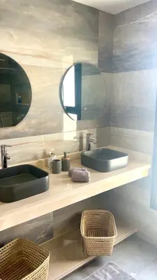 a bathroom with two sinks and a mirror at Villa LAM atlas view in Tameslouht