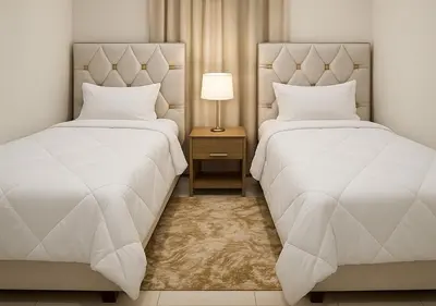 a bedroom with two beds and a night stand with a lamp at Séjour confortables et proche de tous in Marrakech