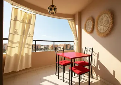 a balcony with a red table and chairs and a window at Séjour confortables et proche de tous in Marrakech