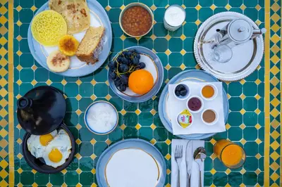 a table with plates of breakfast food on it at Riad Nejma Benyoussef in Marrakech