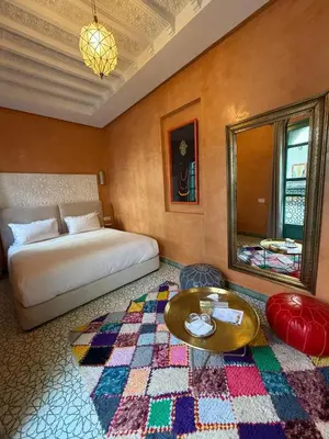 a bedroom with a bed and a table and a mirror at Riad Nejma Benyoussef in Marrakech