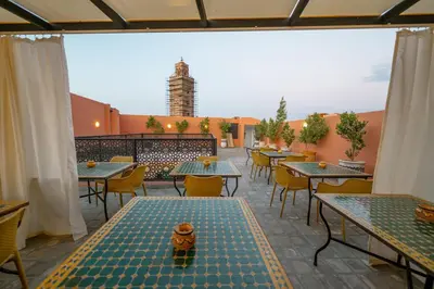 a patio with tables and chairs and a building at Riad Nejma Benyoussef in Marrakech