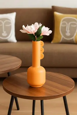 an orange vase with pink flowers on a table at Évasion à Marrakech confort, verdure et piscine in Marrakech