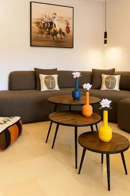 a living room with two tables and a couch at Évasion à Marrakech confort, verdure et piscine in Marrakech
