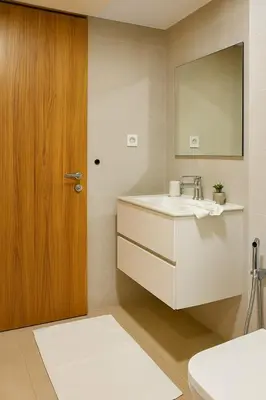 a bathroom with a sink and a wooden door at Évasion à Marrakech confort, verdure et piscine in Marrakech