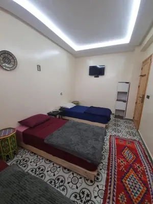 a bedroom with two beds and a tv on the ceiling at Dar Kawtar in Marrakech