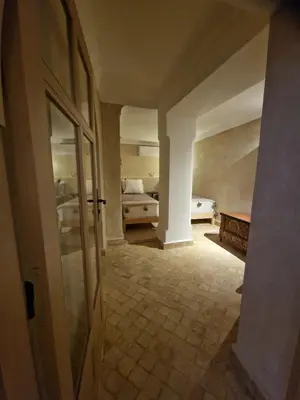 a hallway with a room with two beds and a door at Riad La Brune in Marrakech