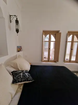 a bedroom with a bed and two windows at Riad La Brune in Marrakech