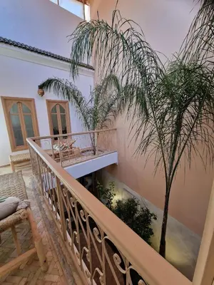 a house with a balcony with a palm tree at Riad La Brune in Marrakech