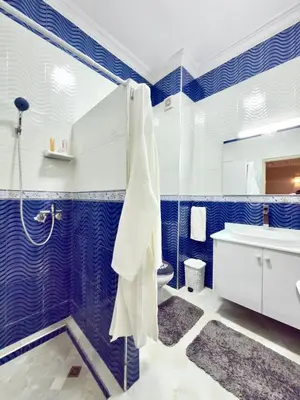 a blue and white bathroom with a tub and a sink at Appartement familial au charme berbère in Marrakech