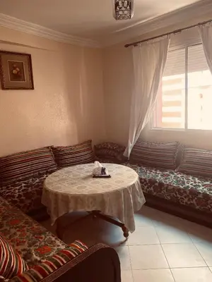 a room with a table and a couch and a window at Apparemment alhamra in Marrakech