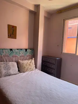 a bedroom with a bed and a dresser and a window at Apparemment alhamra in Marrakech