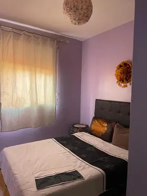 a bedroom with a bed and a purple wall at Apparemment alhamra in Marrakech