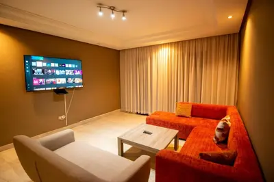 a living room with a couch and a tv at Gueliz carree Eden apartment in Marrakech