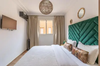 a bedroom with a large bed with a green headboard at Suite Elegante 2 chambres Confort & Style Marrakech in Oulad Akkou