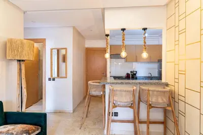 a kitchen with a table and chairs in a room at Suite Elegante 2 chambres Confort & Style Marrakech in Oulad Akkou