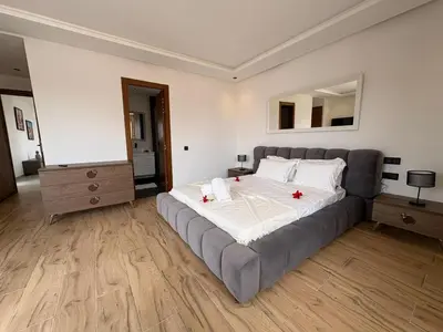 a bedroom with a large bed with two red candles on it at luxury 5 bedroom home in Marrakech