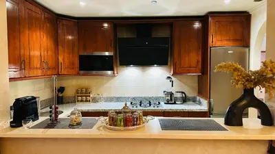 a kitchen with wooden cabinets and a counter top at Heart of Marrakech Chic & Central Gueliz Apartment - Free parking in Marrakech