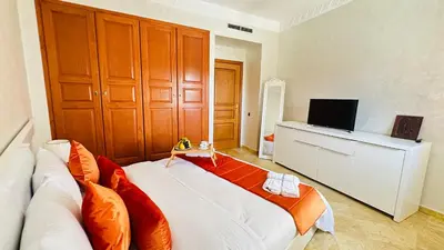 a living room with a white couch and a television at Heart of Marrakech Chic & Central Gueliz Apartment - Free parking in Marrakech