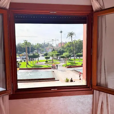 a window in a room with a view of a park at Heart of Marrakech Chic & Central Gueliz Apartment - Free parking in Marrakech