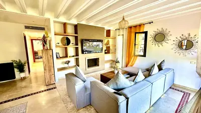 a living room with a couch and a tv at Palmeraie 1BR Appart with Garden, Pools and Tennis in Marrakech
