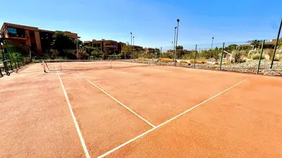 a tennis court with a net on top of it at Palmeraie 1BR Appart with Garden, Pools and Tennis in Marrakech