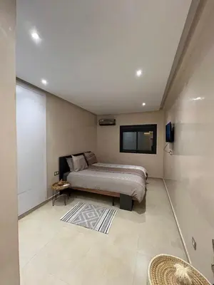 a bedroom with a bed and a tv on the wall at Appartement Design près du Jardin Majorelle in Marrakech