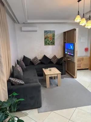 a living room with a black couch and a table at Marrakech,Rouidate in Marrakech