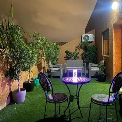 a patio with chairs and a table with a candle at Marrakech,Rouidate in Marrakech