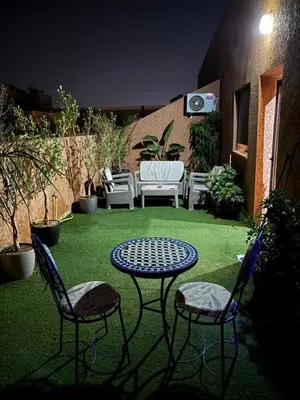 a patio with two chairs and a table and a table and chairs at Marrakech,Rouidate in Marrakech