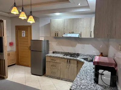 a kitchen with wooden cabinets and a refrigerator at Marrakech,Rouidate in Marrakech