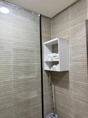 a bathroom with a shower with a shelf and towels at Comfort Luxe 2BR Pool & Balcony in Marrakech